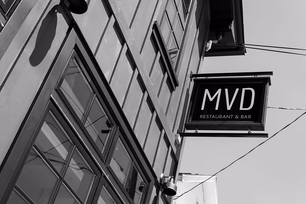 Sign reading 'MVD Restaurant & Bar' hanging from a corner building facade.